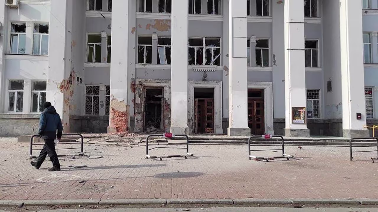 A man walks past a the central post office building damaged by night shelling in Chernihiv, Ukraine, Wednesday, March 30.