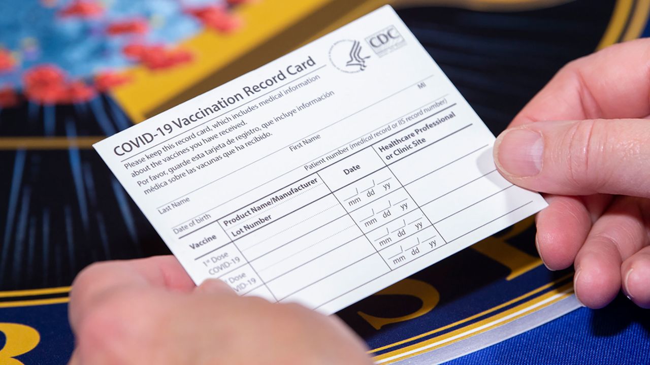 A Department of Health and Human Services employee holds a Covid-19 vaccine record card on November 13 in Washington, DC.