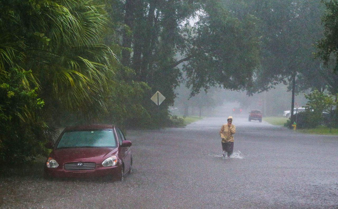 A resident walks through rising flood waters in Savannah, Georgia, as heavy rains from Tropical Storm Debby caused widespread flooding on Monday, August 5