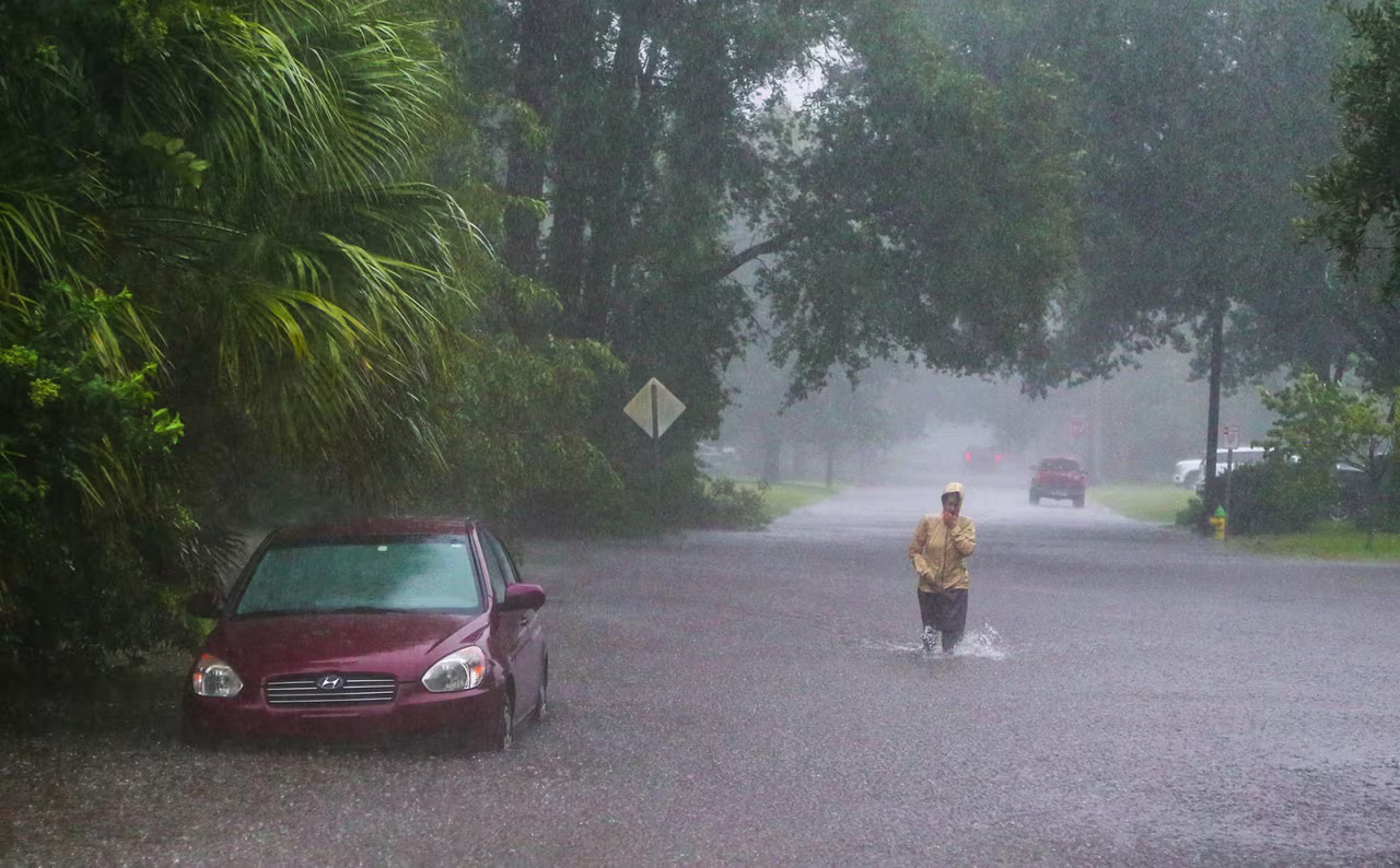 A resident walks through rising flood waters in Savannah, Georgia, as heavy rains from Tropical Storm Debby caused widespread flooding on Monday, August 5