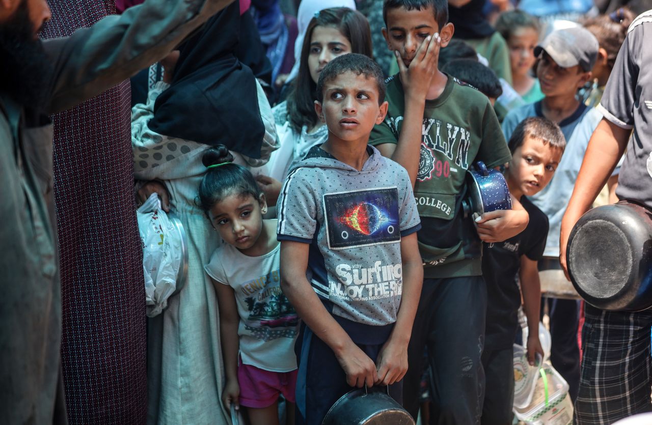 Palestinians are queuing for meal rations at a communal food distribution point in Deir al-Balah, Gaza, on June 10.