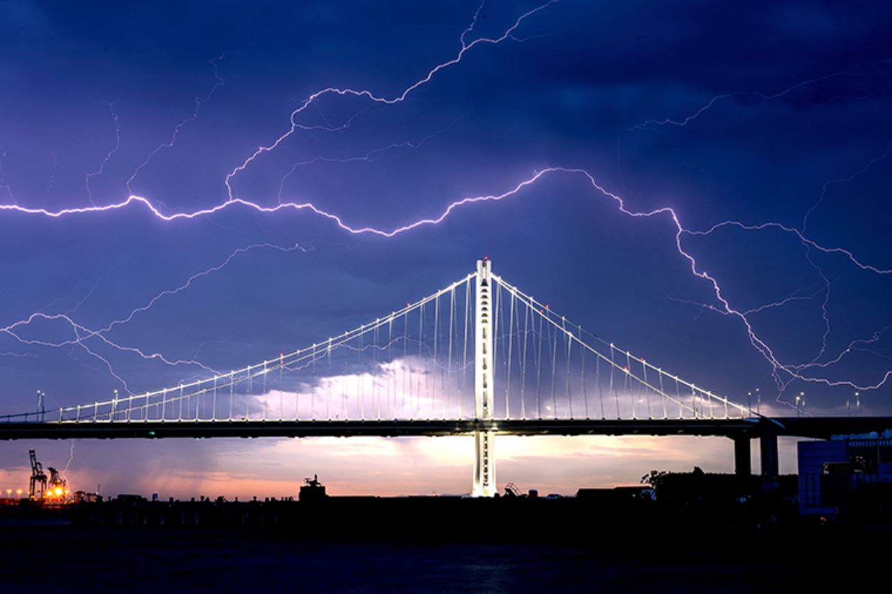 Lightning forks seen over the San Francisco-Oakland Bay Bridge as a storm passes over Oakland, California on Sunday on August 16, 2020. Numerous lightning strikes early Sunday sparked brush fires throughout the region. 
