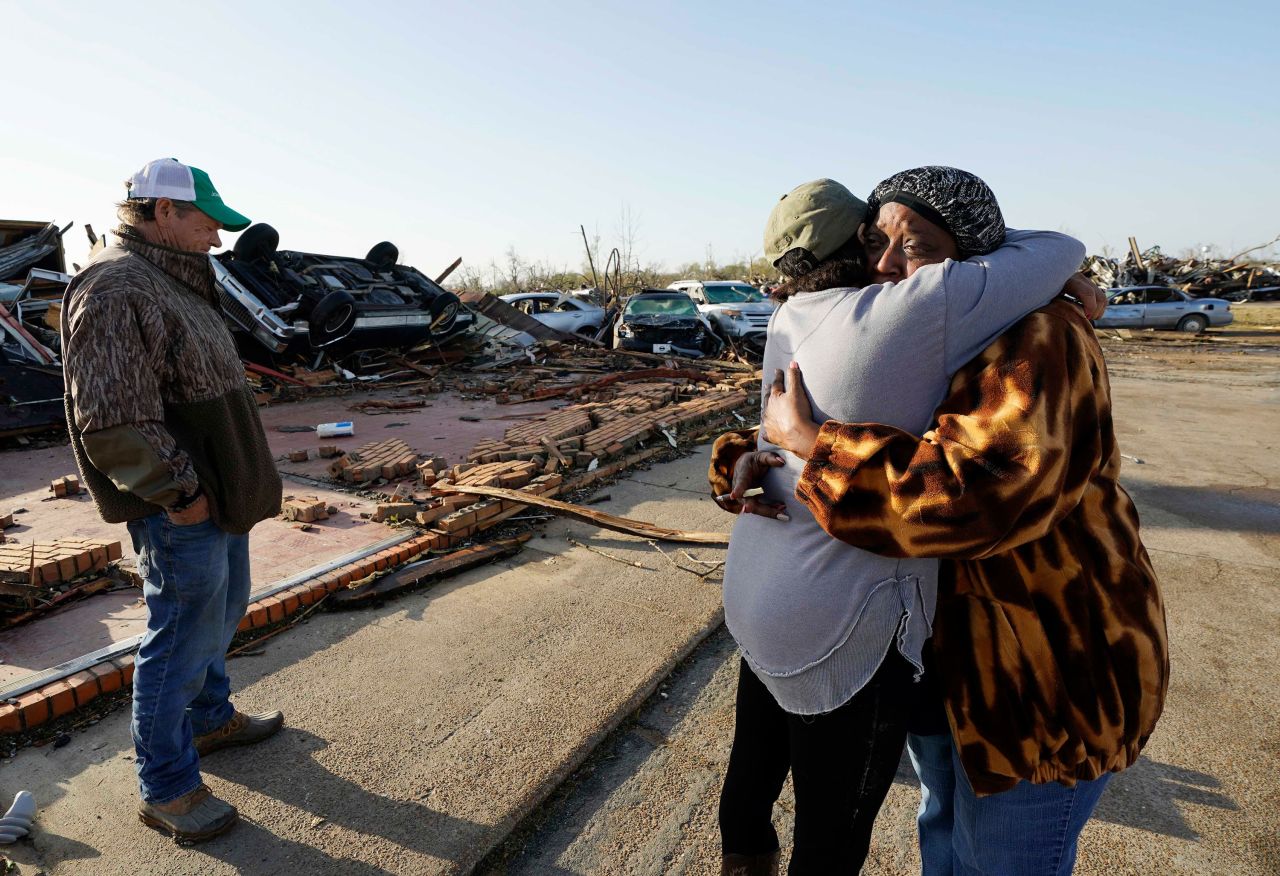 Tracy Hardin, center, who with her husband Tim, left, own Chuck's Dairy Bar, consoles a neighbor in Rolling Fork, Mississippi, on March 25. 