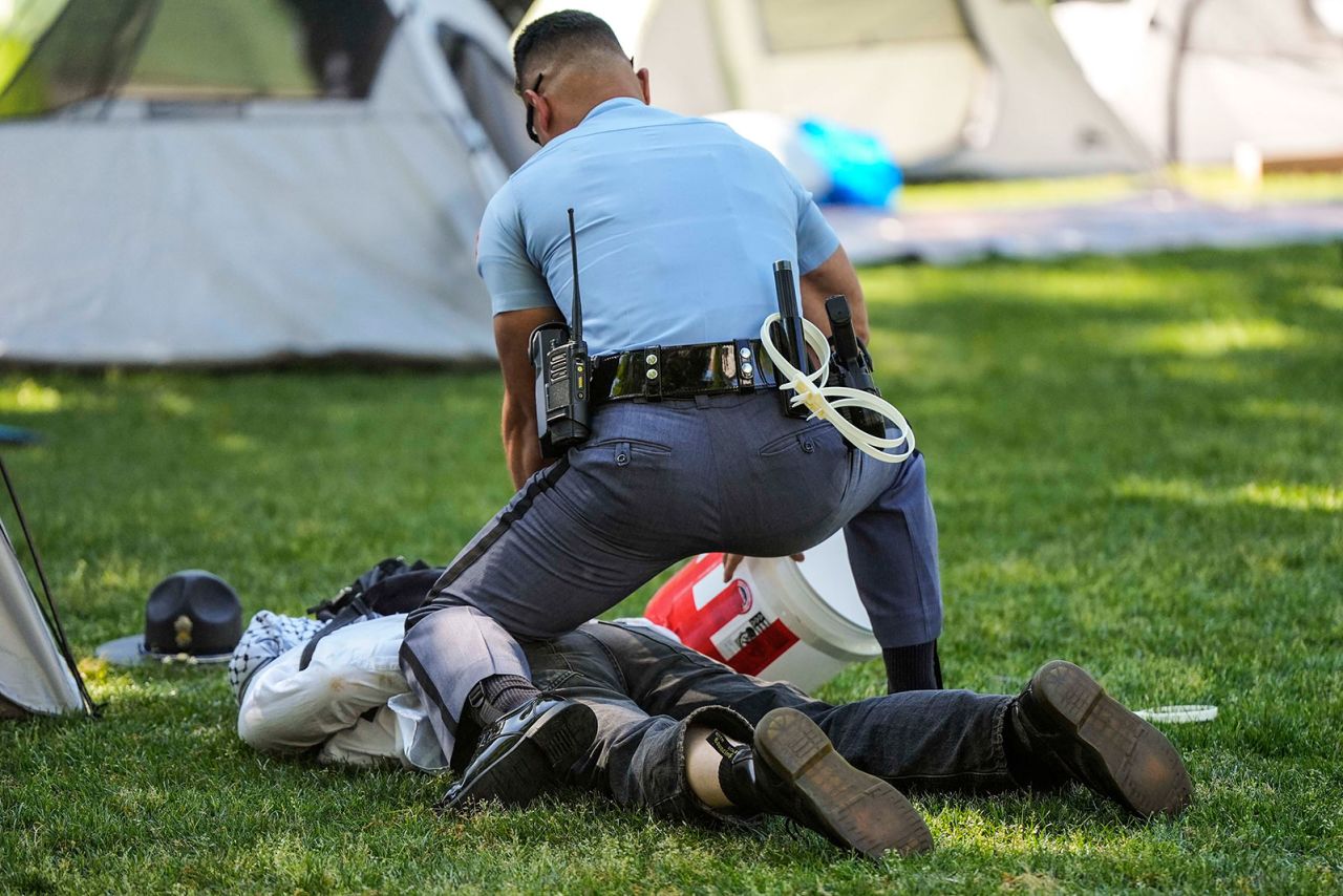 A Georgia State Patrol officer detains a protester on the campus of Emory University during a pro-Palestinian demonstration Thursday, April 25, in Atlanta, Georgia.