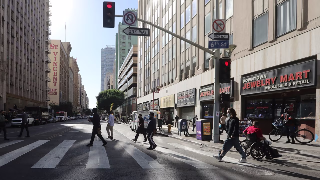 Pedestrians cross a street in downtown Los Angeles, on Thursday, December 3.