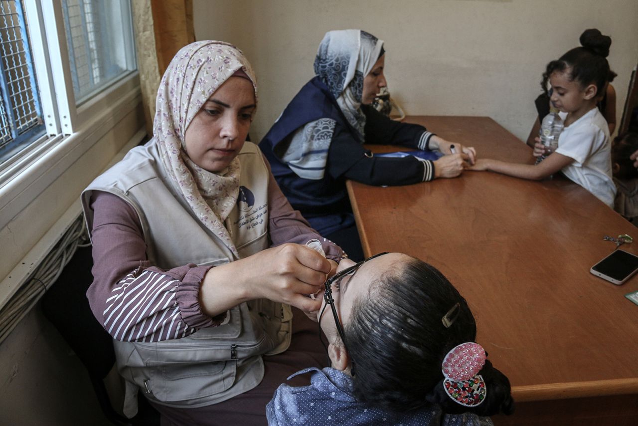 Health workers vaccinate a child against polio at the United Nations Nuseirat Health Center, in the Nuseirat refugee camp, central Gaza, on September 1.