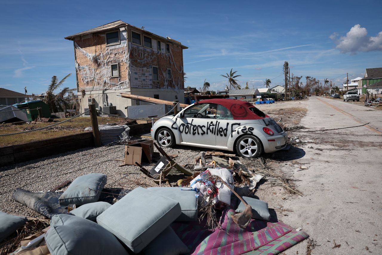 A warning for looters is painted on the side of a car in Pine Island on Monday.