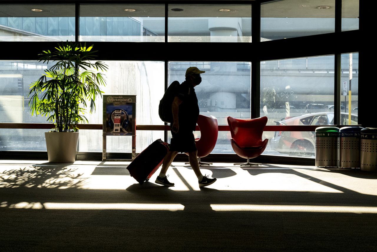A traveler wearing a protective mask walks in San Francisco International Airport in San Francisco, California, on Monday, Dec. 21, 2020. 