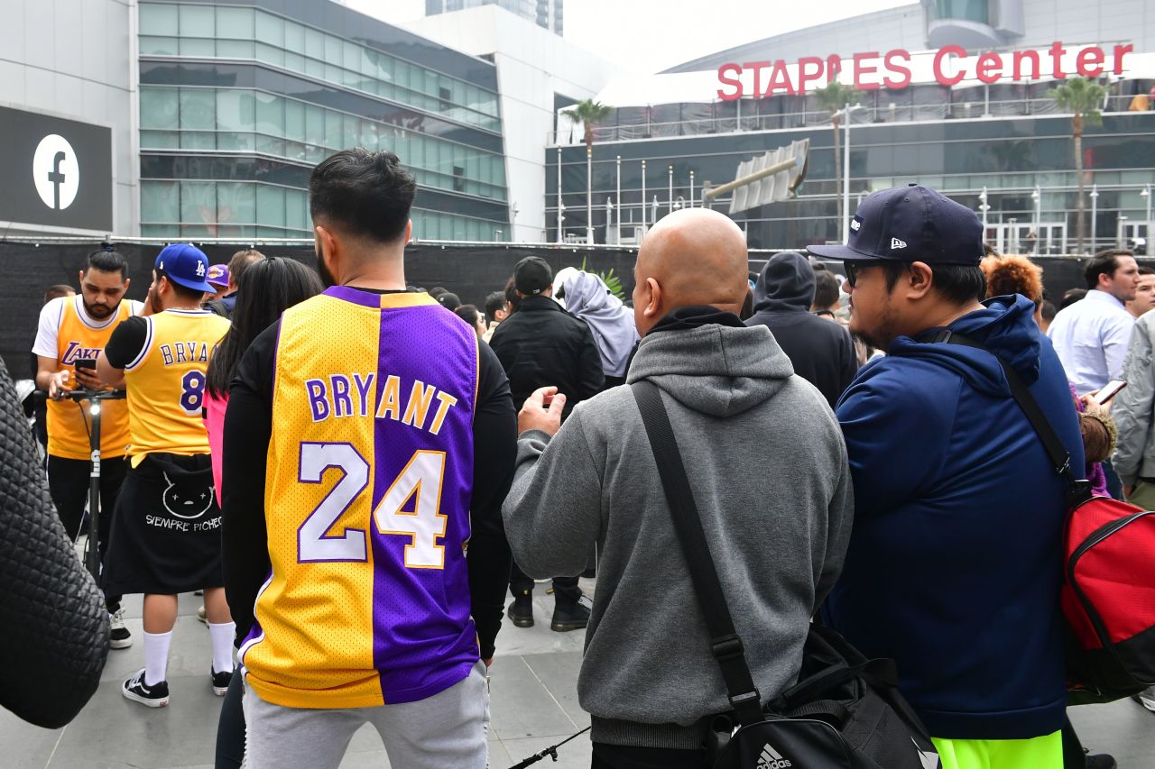 People gather around a makeshift memorial for former Los Angeles Lakers player Kobe Bryant after learning of his death Sunday at LA Live plaza in front of Staples Center in Los Angeles.