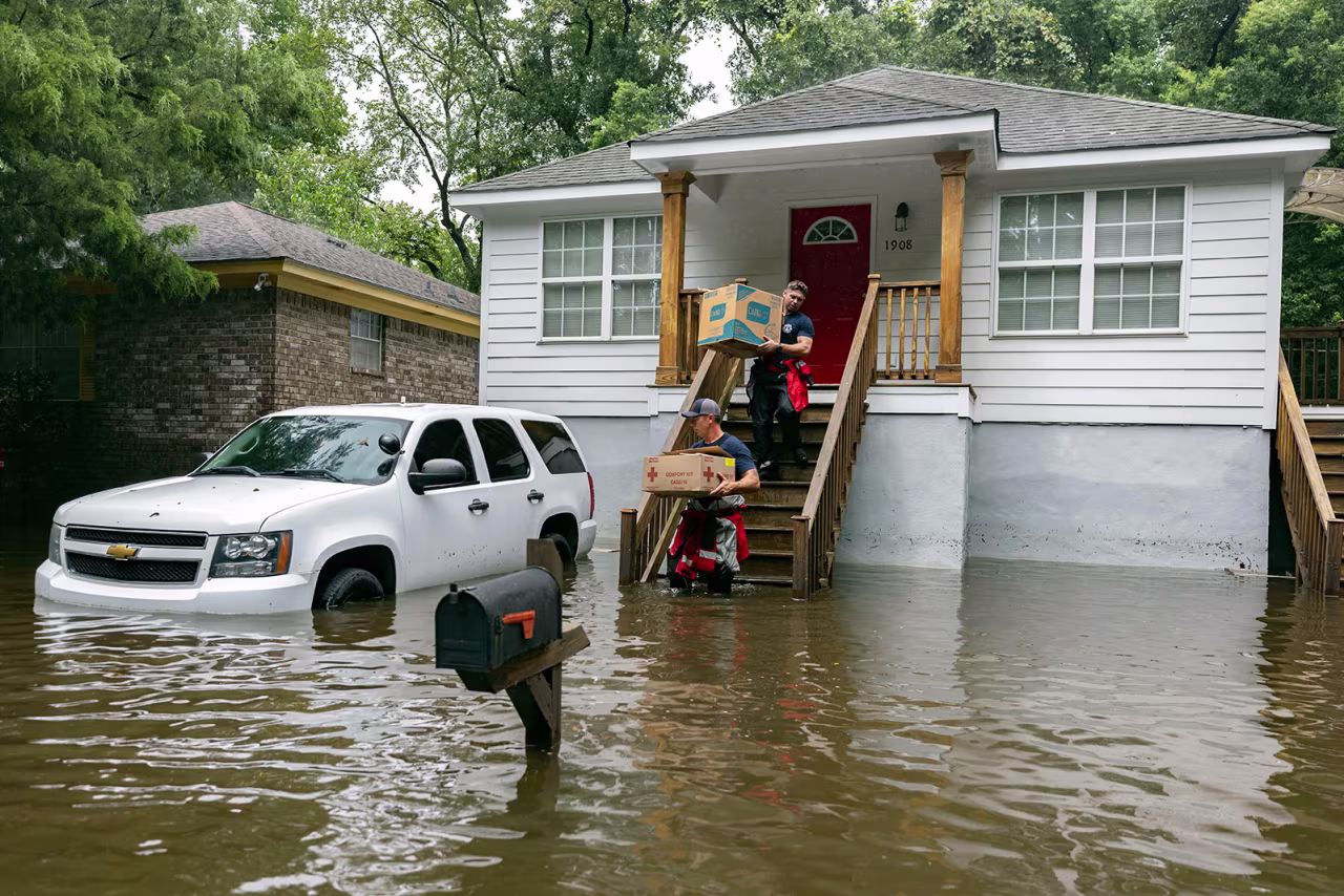 Firefighters Ron Strauss, top, and Andrew Stevenson, below, carry food to residents stranded in flood water in Savannah's Tremont Park neighborhood on August 6. 