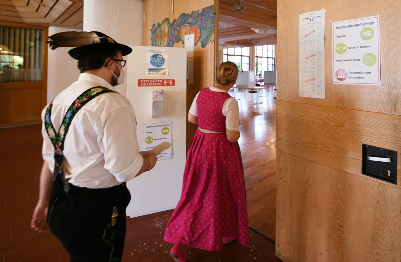 A couple dressed in traditional Bavarian costume arrive at a polling station in Oberammergau, Germany on Sunday, September 26.