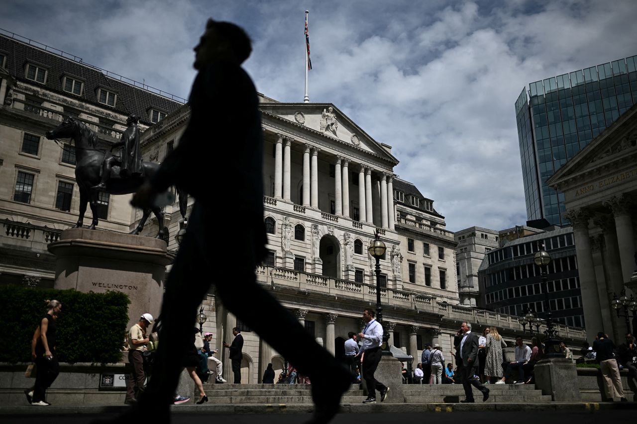 Pedestrians walk past the Bank of England, Britain's central Bank, in London on June 20.