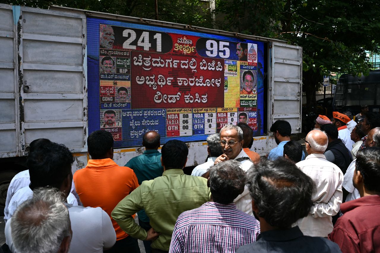 People watch latest vote counting results live on a large screen for India's general election at the Bharatiya Janata Party office in Bengaluru, India, on June 4.