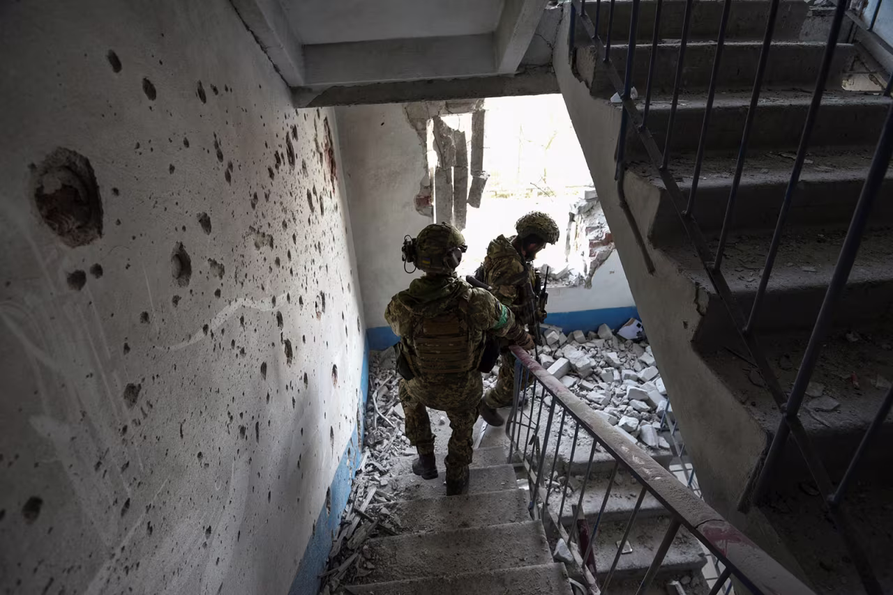 Ukrainian servicemen inspect a residential building damaged during a Russian military strike in Bakhmut, Ukraine, on January 17. 