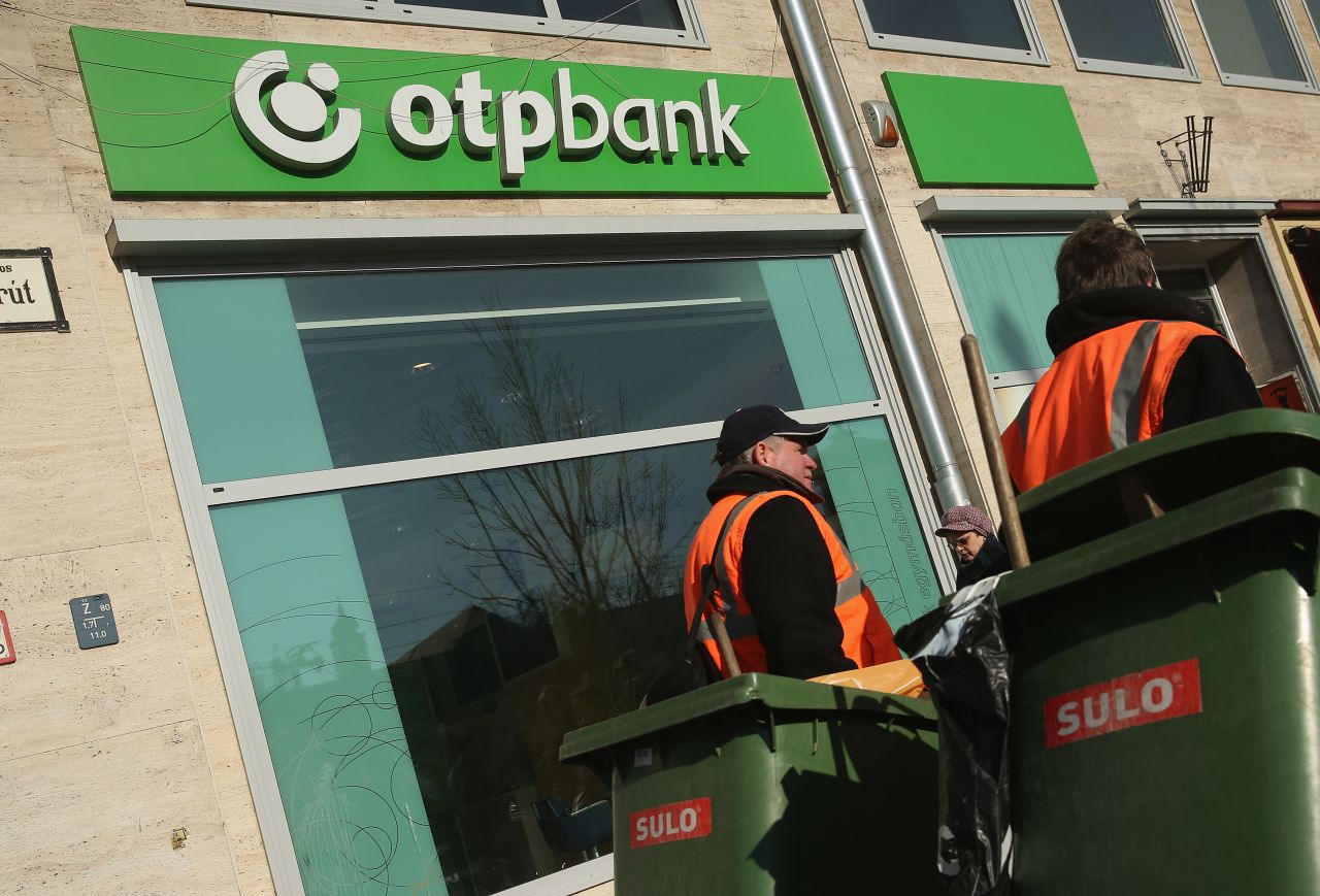 Garbage collectors walk past a branch of OTP Bank in the city center on February 16, 2015 in Budapest, Hungary.