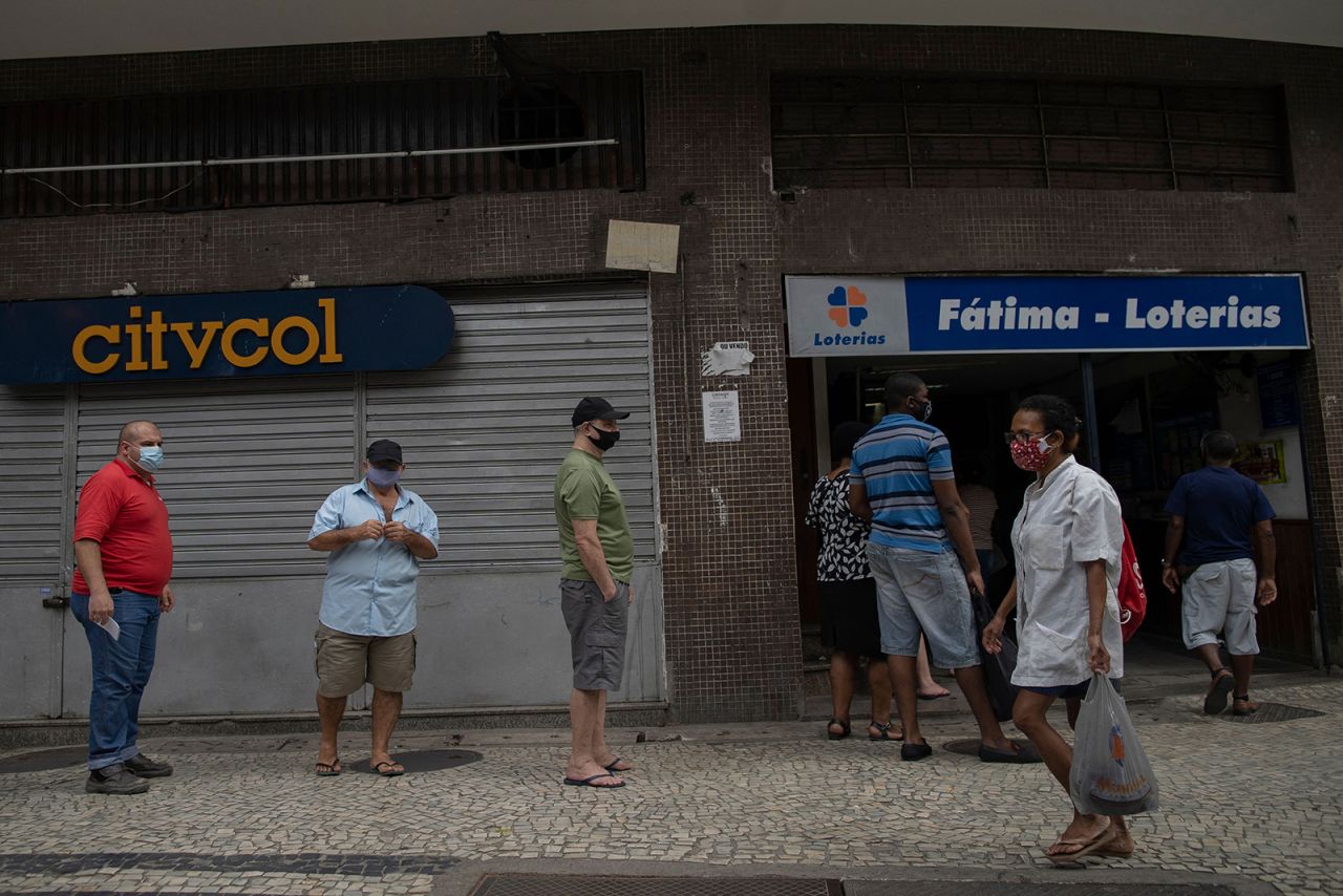 People are seen on a queue to access a lottery shop at the Lapa neighborhood during the Covid-19 pandemic in Rio de Janeiro, on April 8.