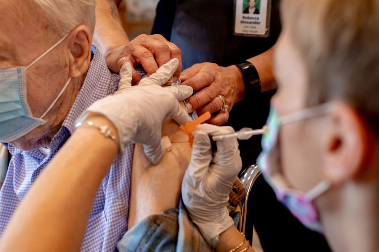 A healthcare worker administers a third dose of the Pfizer-BioNTech Covid-19 vaccine at a senior living facility in Worcester, Pennsylvania on August 25.