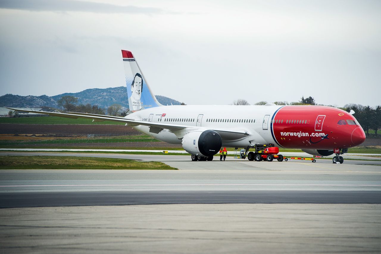 Workers wearing high-visibility jackets stand near a passenger aircraft, operated by Norwegian Air Shuttle ASA, grounded at Stavanger Airport in Stavanger, Norway, on April 30. 