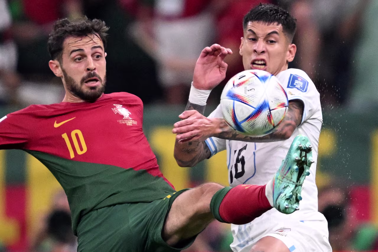 Portugal's Bernardo Silva, left, fights for the ball with Uruguay's Mathias Olivera on Monday.