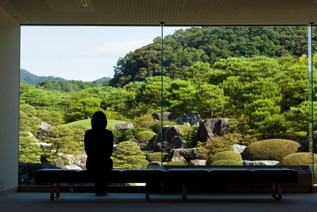 A visitor stands in front of a "frame"-style window designed to center the garden.