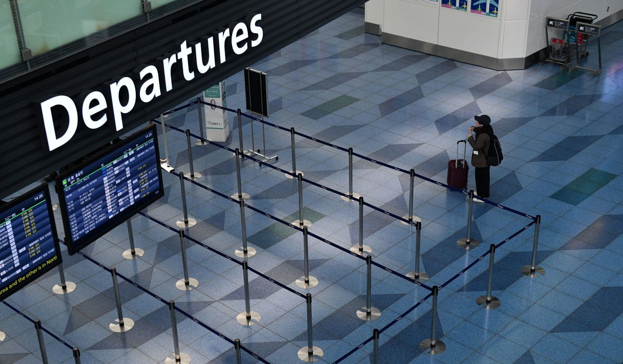 A passenger pauses next to an empty departure gate at Haneda Airport on March 17 in Tokyo, Japan. 