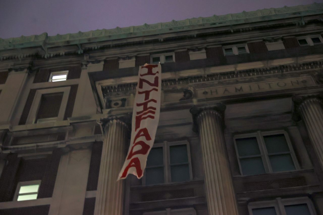 A banner that reads "intifada," the Arabic word for uprising, hangs from Hamilton Hall after protesters barricaded themselves inside.