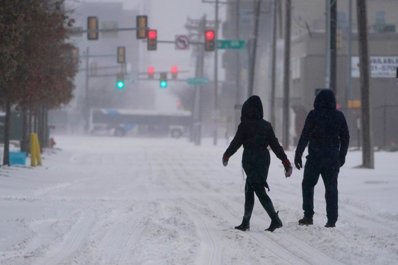 People walk down a street during a winter storm in Oklahoma City, Sunday, February 14.