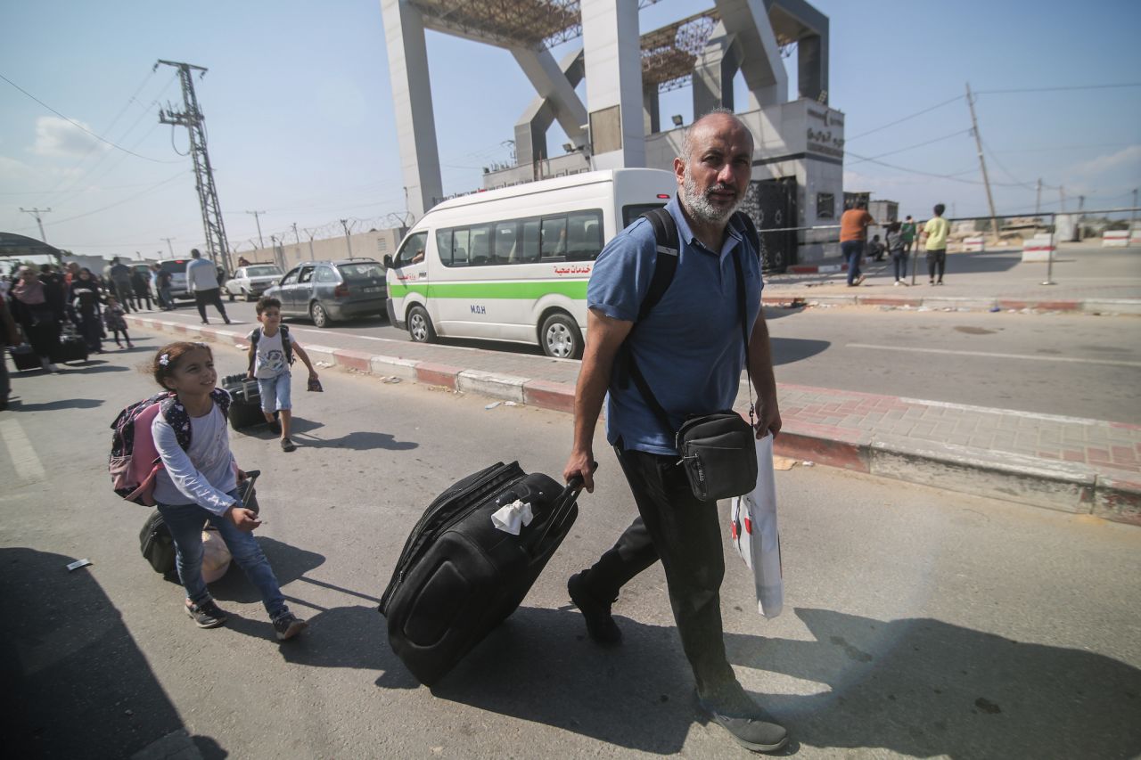 A Palestinian man and kids arrive at the Rafah border crossing on Satuday.