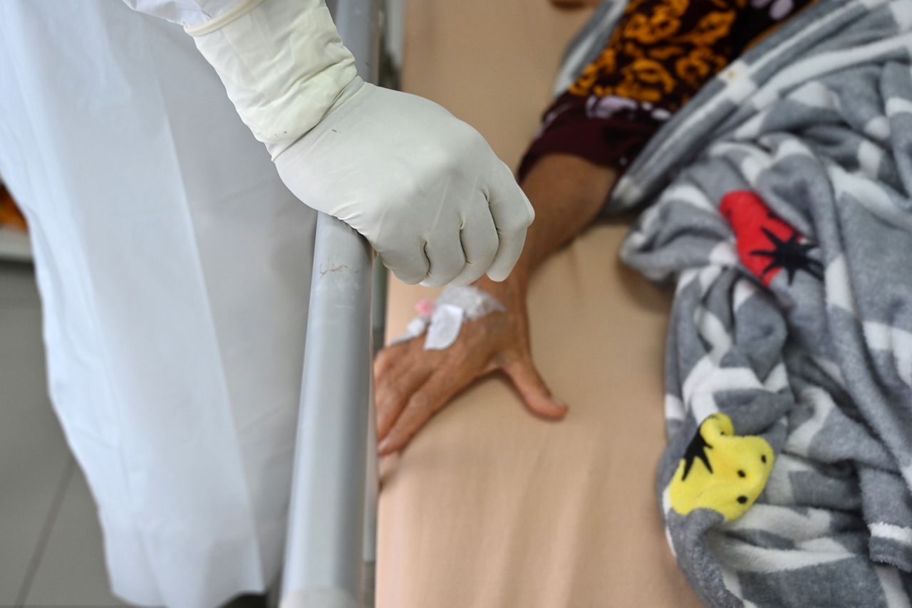 A doctor's hand is seen next to a Covid-19 patient's hand at a general hospital in Bogor, Indonesia, on January 25.