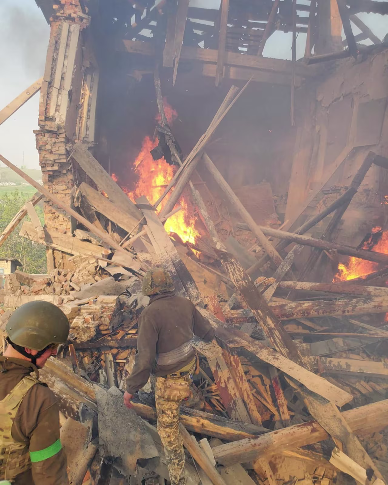 Emergency crew work near a burning debris, after a school building was hit as a result of shelling, in the village of Bilohorivka, Luhansk, on Ukraine, May 8.