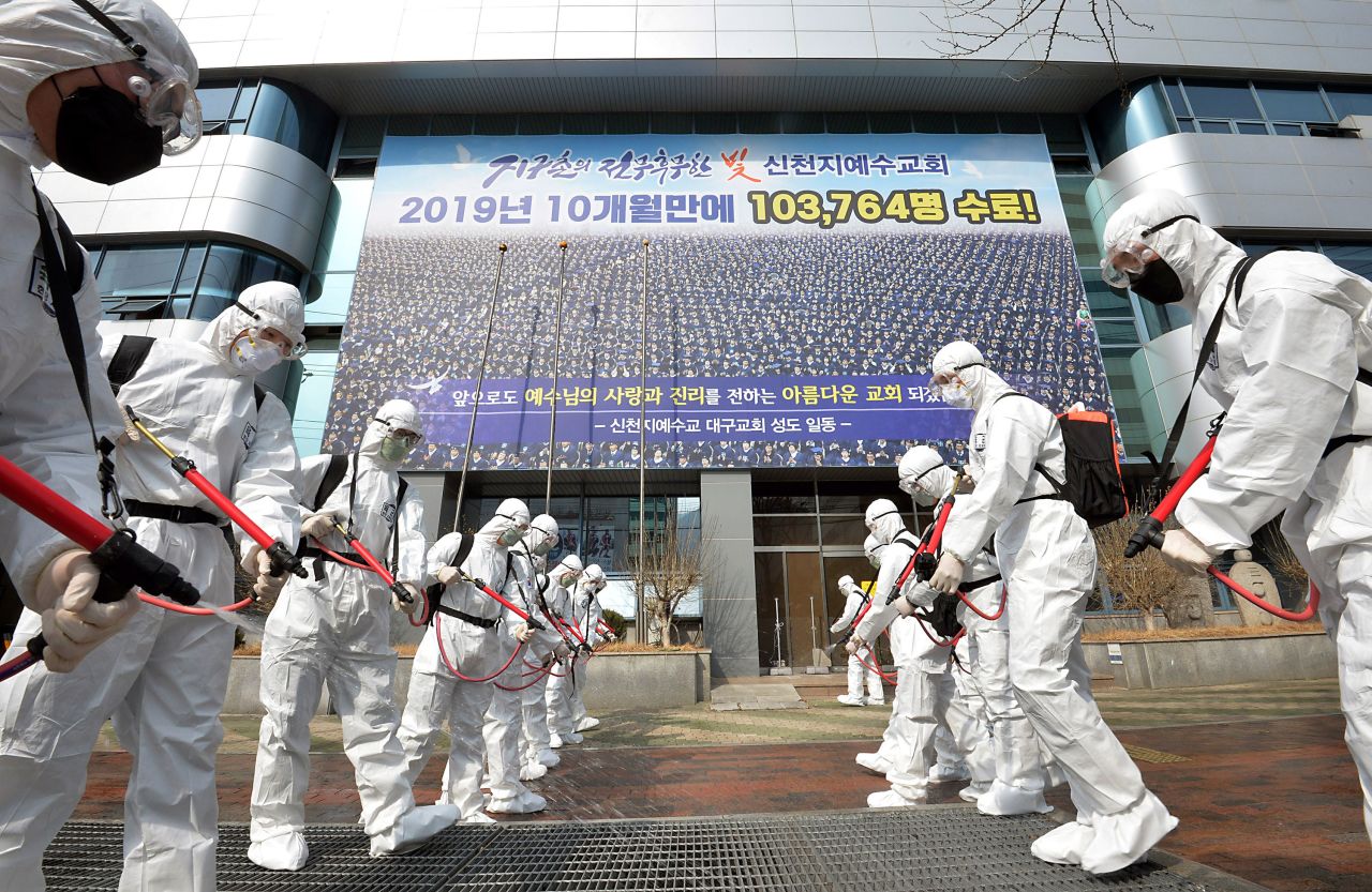 Workers spray disinfectant in front of a branch of the Shincheonji Church of Jesus in Daegu, South Korea, on March 1.