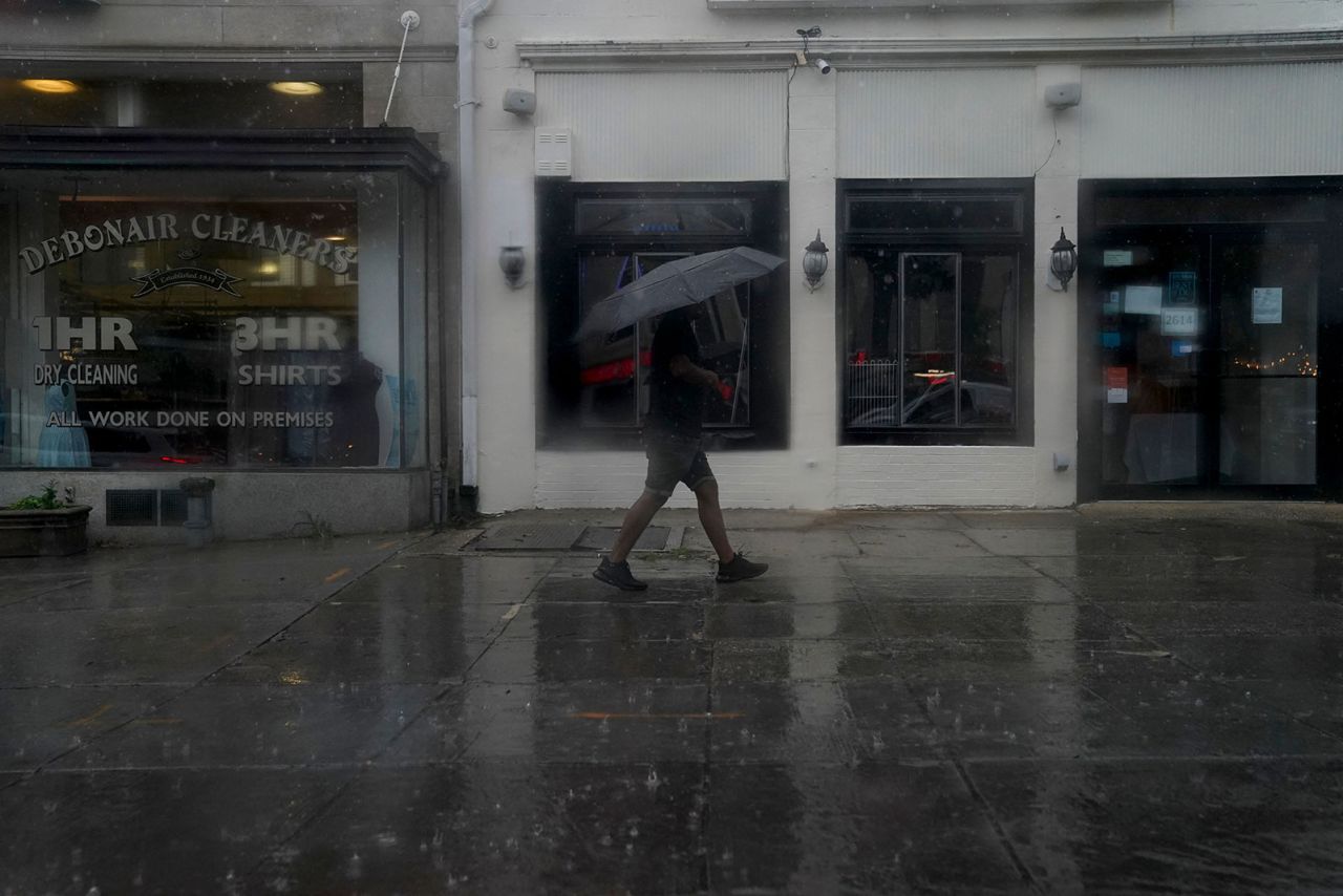 A pedestrian carries an umbrella while walking through rain in Washington, DC, on August 7.