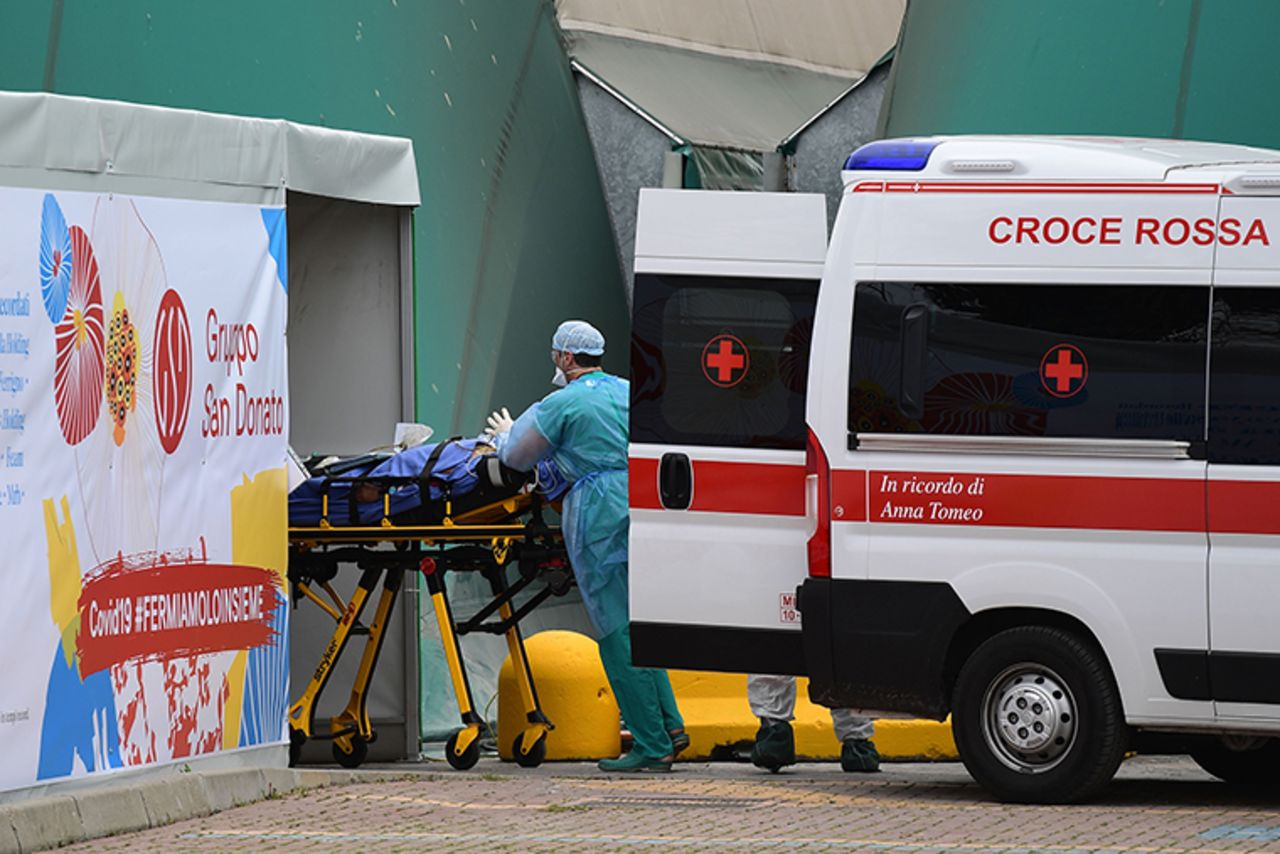 A medical worker moves a patient from an Italian Red Cross ambulance into an intensive care unit set up in a sports center outside the San Raffaele hospital in Milan, in the hard hit Lombardy region of Italy, on Monday, March 23. 