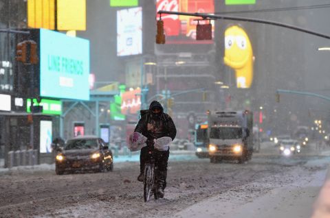 A person rides their bicycle in Times Square in New York City during a winter storm on Monday.