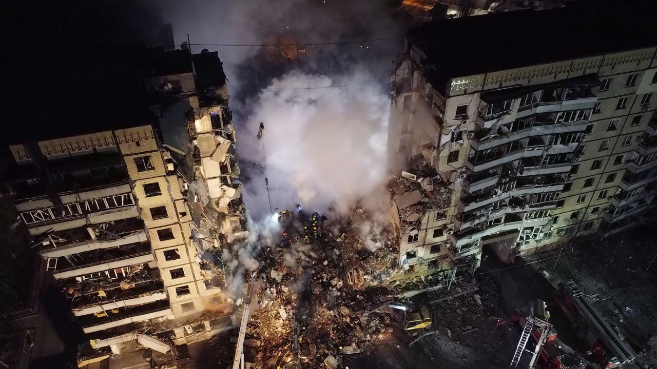 Firefighters conducting search and rescue operations at a residential building hit by a missile on January 15, in Dnipro, Ukraine. 