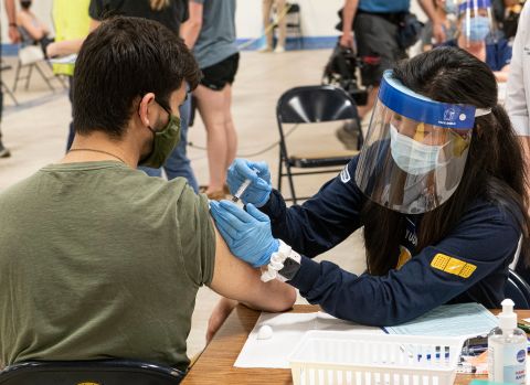 Kent State University student Jarrett Woo gets his Johnson & Johnson COVID-19 vaccination from Kent State nursing student Allie Rodriguez in Kent, Ohio, on April 8.
