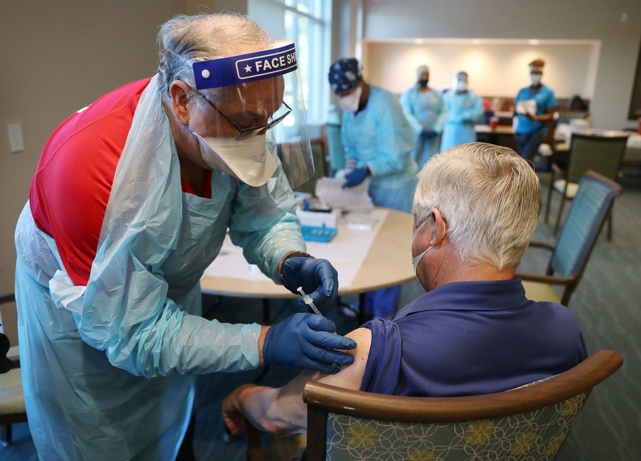 A healthcare worker administers a Pfizer-BioNtech Covid-19 vaccine at the John Knox Village Continuing Care Retirement Community on January 6, in Pompano Beach, Florida.