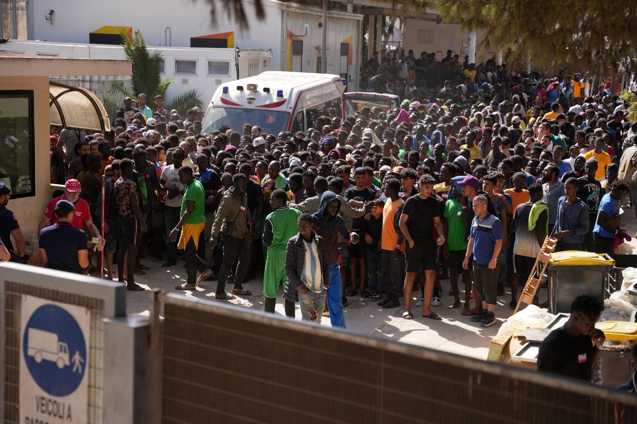 Migrants wait to receive registration papers from the Red Cross on the Italian island of Lampedusa on September 17.