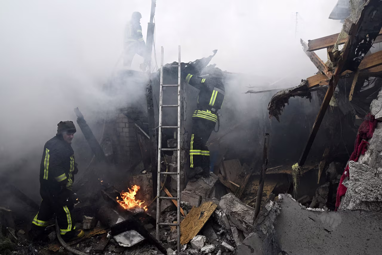Firefighters work to extinguish flames in a house hit by shelling in Kherson on Sunday. 