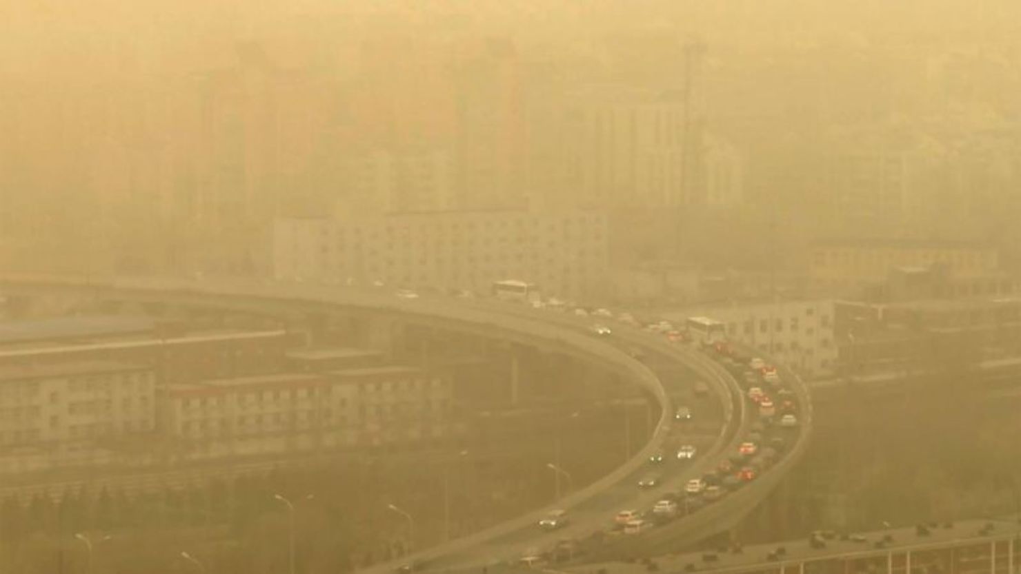 Vistos a través de una ventana de vidrio, los autos circulan por una autopista durante una tormenta de polvo en medio de una fuerte contaminación en Beijing, el 10 de marzo de 2023.