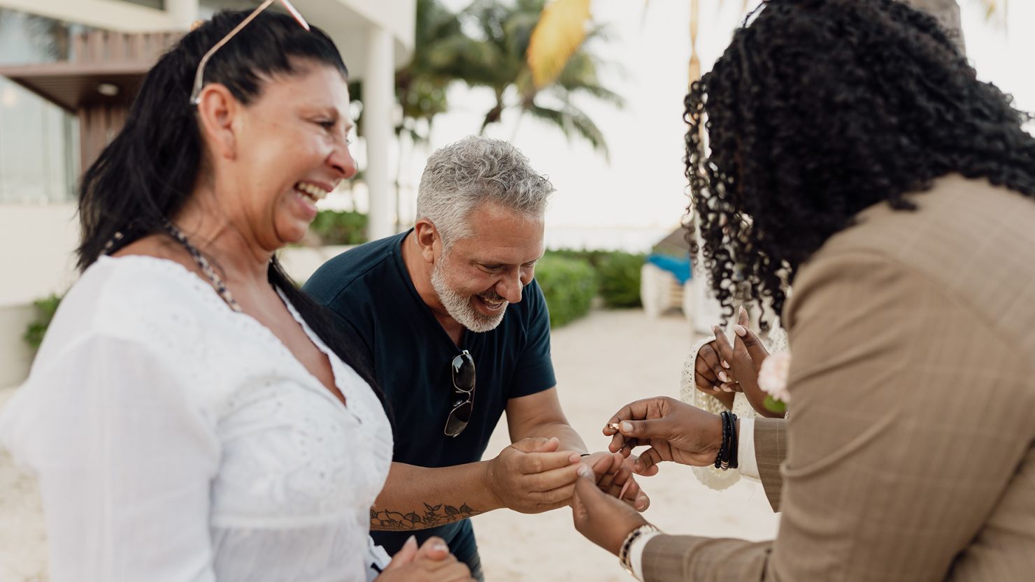 Shannon Jackson (right) and their new spouse Calivé share a moment with the couple (left) that lent them their own wedding rings.