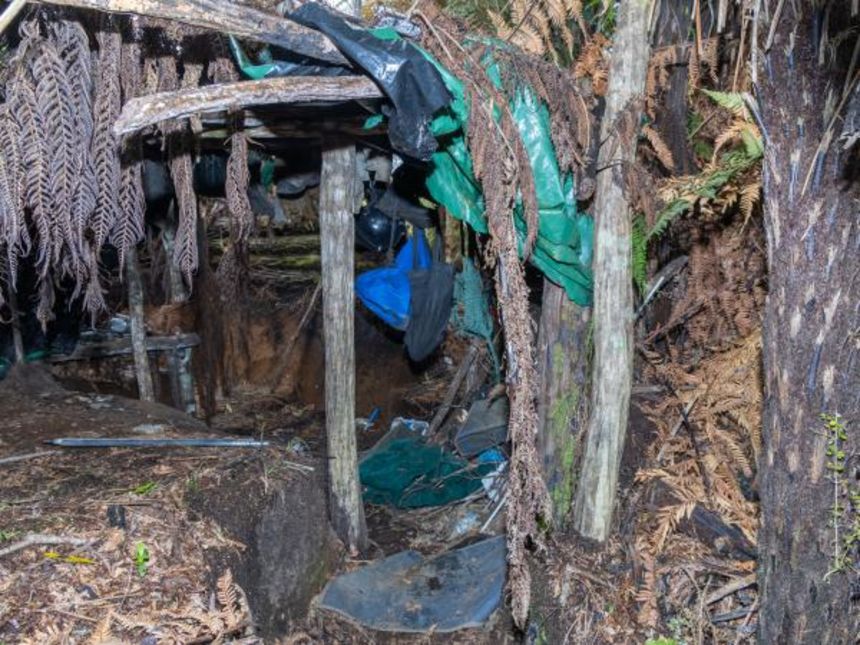 The campsite east of Upper Marocopa consists of a basic wooden structure with a plastic tarpaulin roof built into the surrounding foliage.