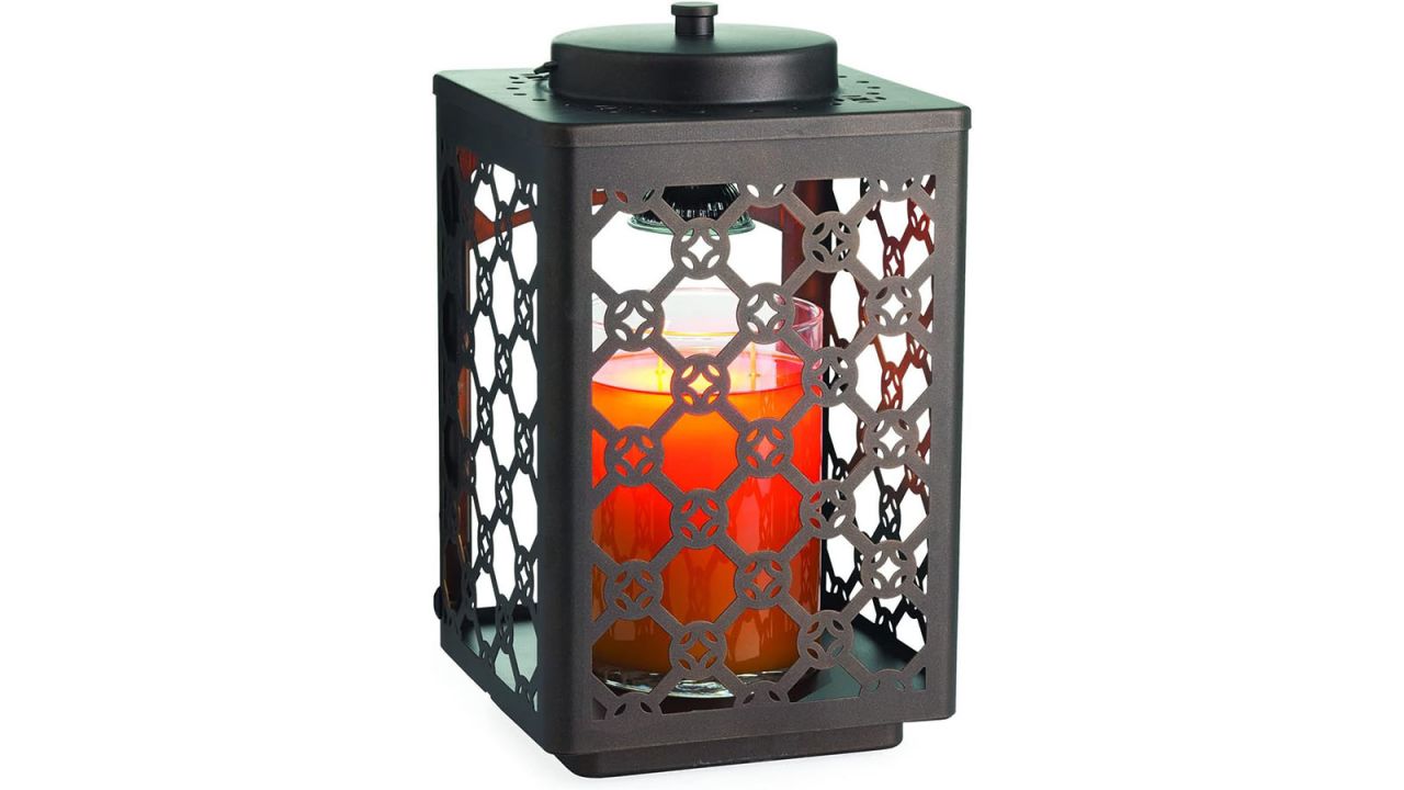 Candle warmer lantern with medium sized candle inside placed against a white background.