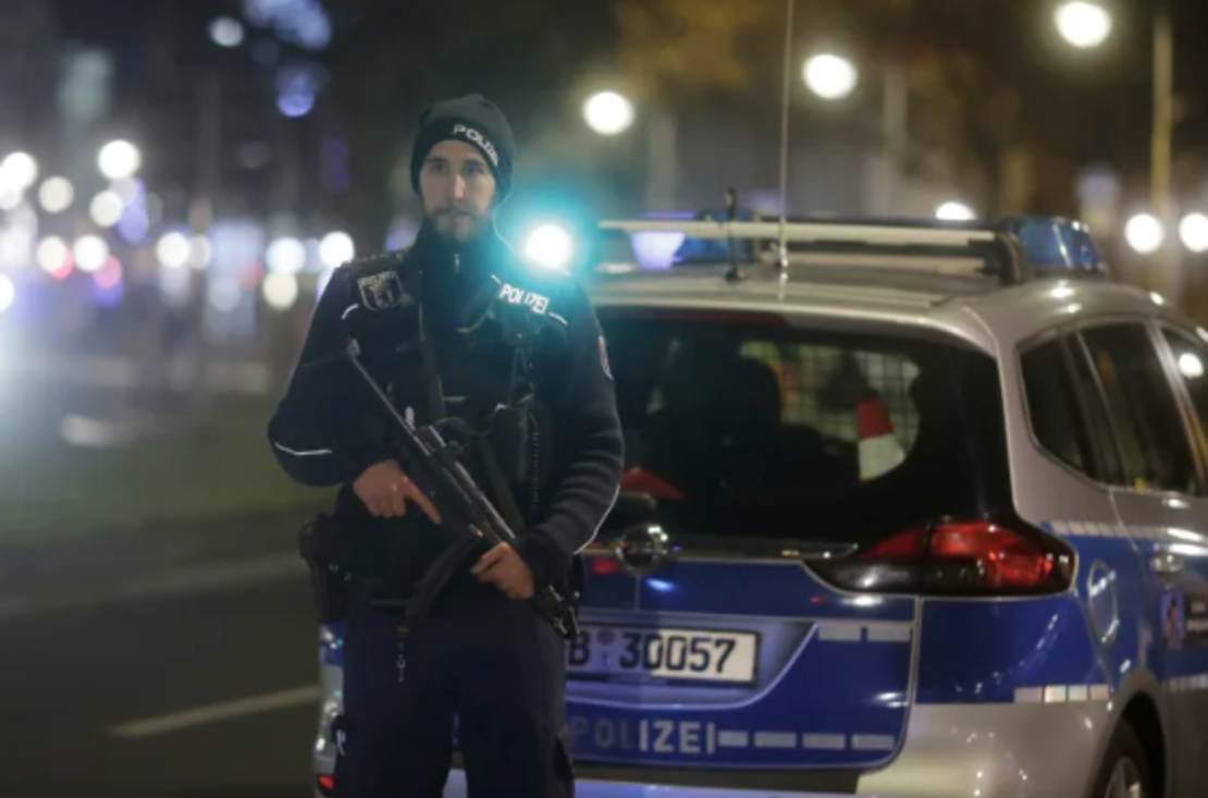 Un oficial de Policía armado se encuentra cerca de la escena.