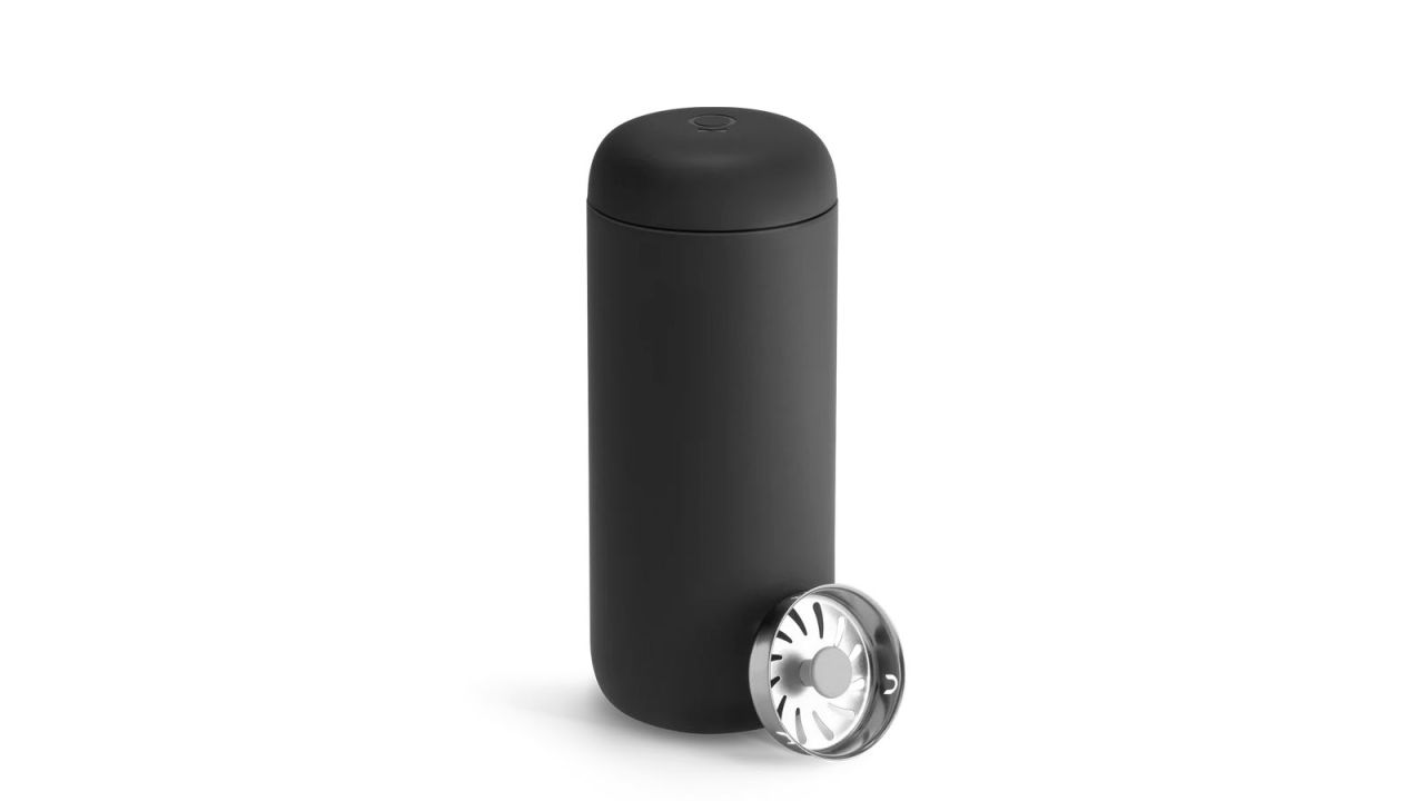 Black move mug with splash guard placed next to it.