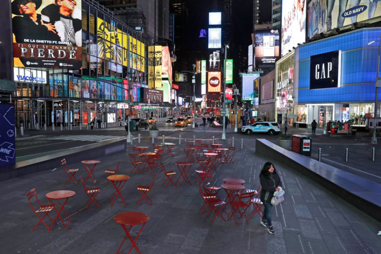 A woman walks through a quiet Times Square in New York on Monday, March 16.