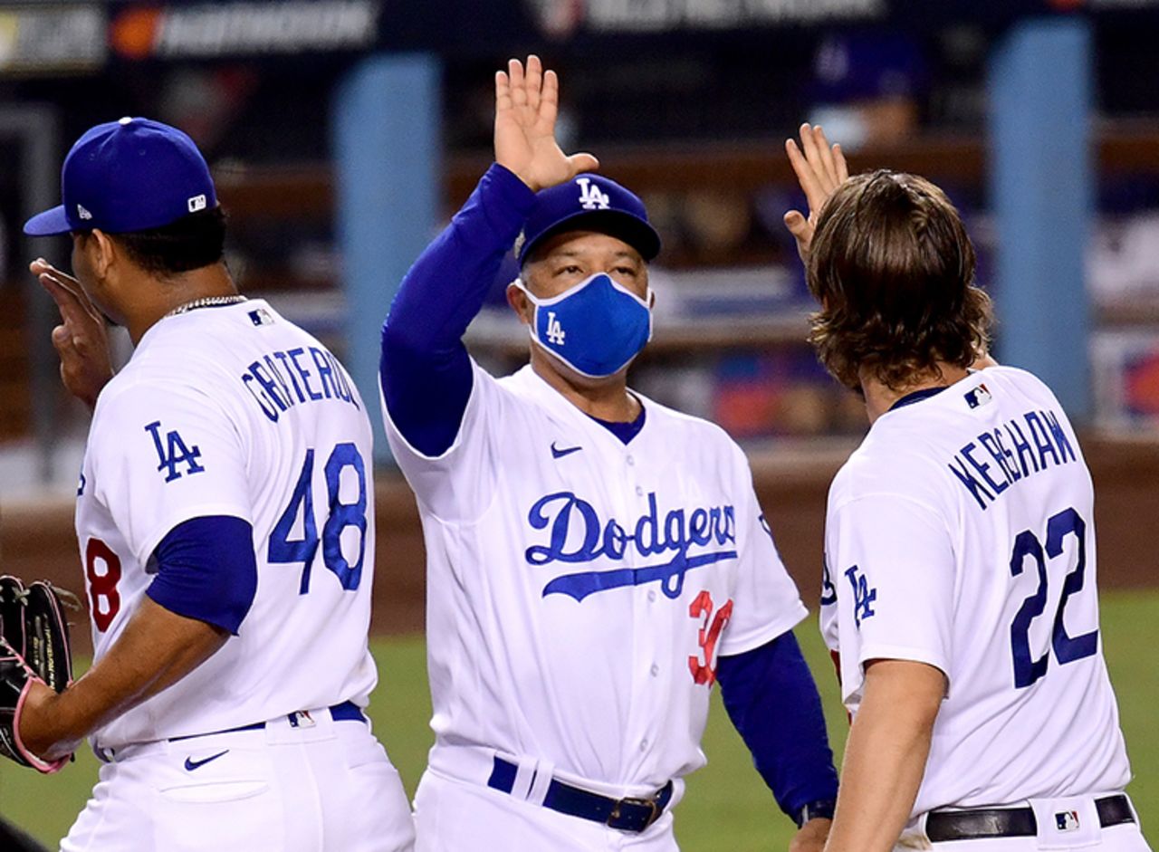 Manager Dave Roberts #30 of the Los Angeles Dodgers celebrate a 3-0 win with Clayton Kershaw #22 and Brusdar Graterol #48, to eliminate the Milwaukee Brewers after game two of the National League Wild Card Series at Dodger Stadium on October 01, 2020 in Los Angeles, California. 