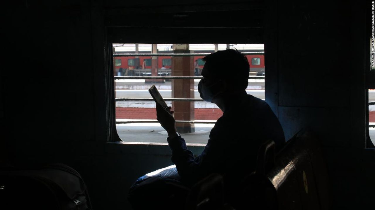 A passenger looks at his mobile phone on a local train in the state of West Bengal in Kolkata, India, on Nov. 11, 2020. 