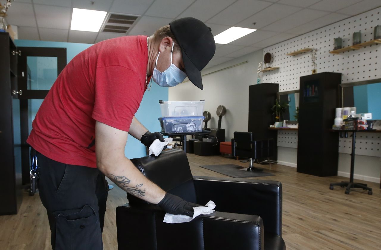 Brian Waldret, co-owner of Hello Salon in Laveen, Arizona, disinfects surfaces in the salon on May 7, in preparation for reopening after being closed for several weeks due to the coronavirus.