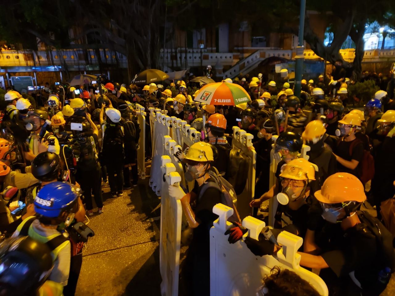 Protesters erect plastic street barriers as shields as they face off with police.